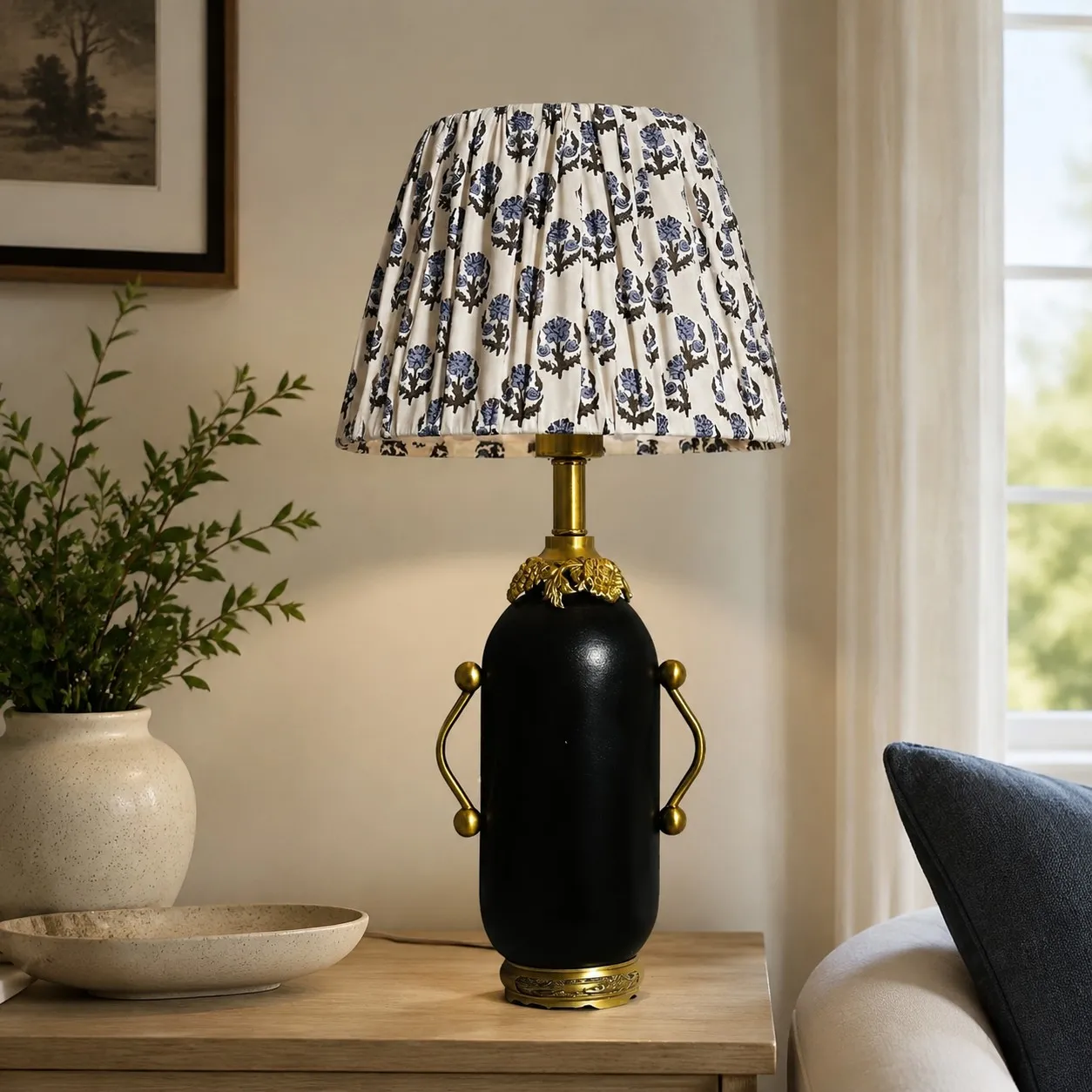 Matte black floral table lamp styled beside a green armchair